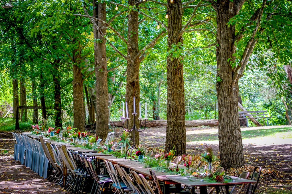 Long banquet table set under the trees at a bush eco wedding