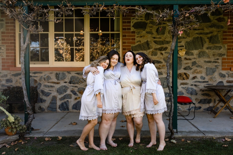 A bride and her friends all hug before getting ready for the wedding