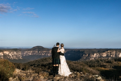 A wedding couple embraces as they look out over the Blue Mountains