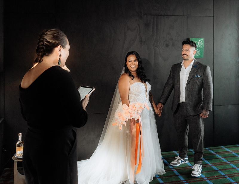 Rachael Calvert, Celebrant, officiates the wedding ceremony of a bride and groom in their Airbnb in Hobart Tasmania