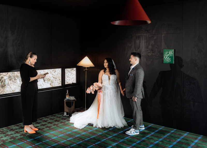 Rachael Calvert, Celebrant, officiates the wedding ceremony of a bride and groom in their Airbnb in Hobart Tasmania